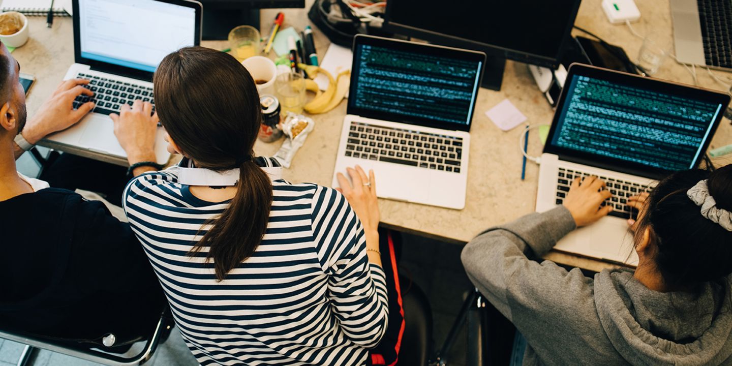 KI-Entwicklung in Unternehmen: Ein Team von Entwicklern programmiert KI-Software.