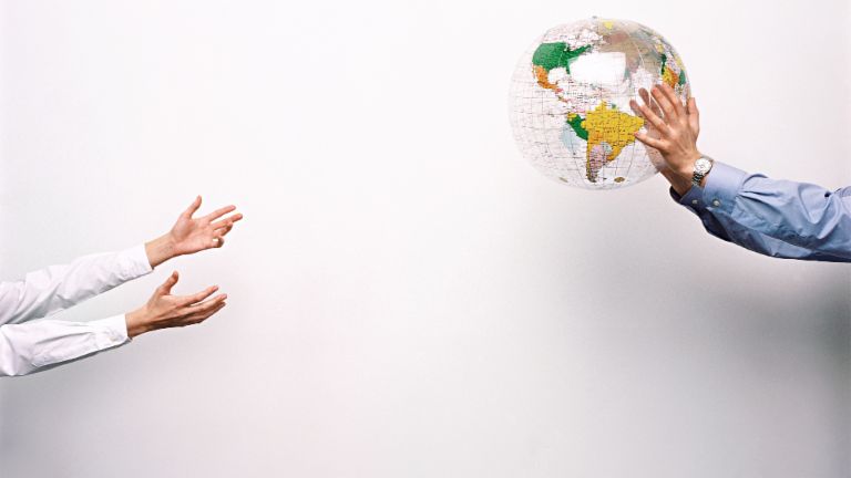 Zwei Männer werfen sich einen Plastik-Globus zu